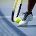 A tennis ball is wedged in between a shoe and a racquet on Tuesday, May 7. Daniel Brenner I AnnArbor.com